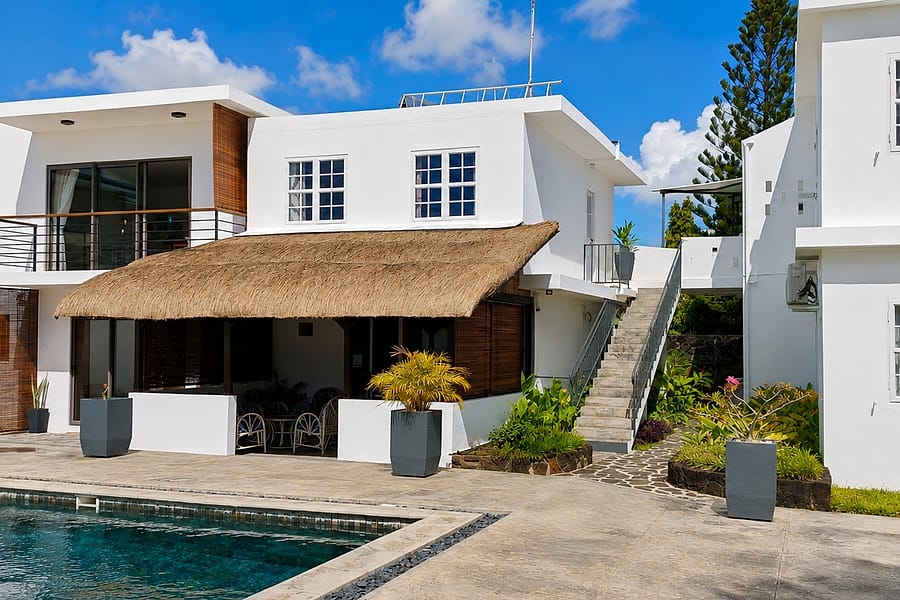 The white buildings of Le Beau Manguier, the thatched veranda and the pool