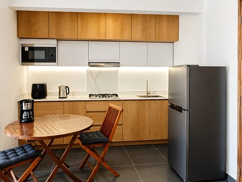 A fitted kitchen in one of the units, with its wooden table and chairs